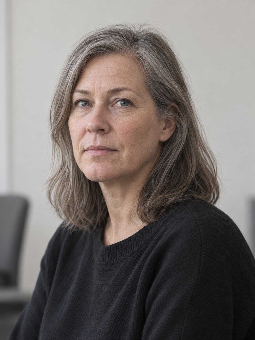 Marika Halme neuvotteluhuoneessa, katse kameraan, vaalea tausta.